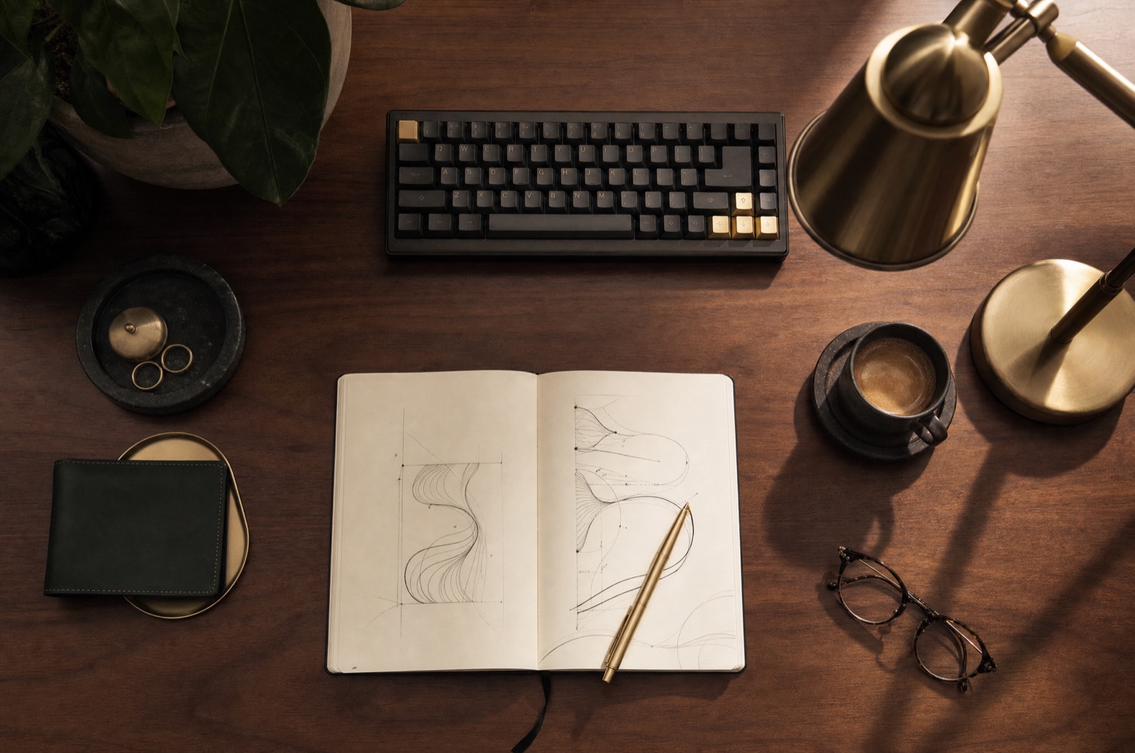 A clean walnut desk with a notebook of system sketches